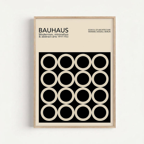 A framed poster with cream background featuring black text reading "BAUHAUS" and details about modernism, minimalism and abstract arts from 1919-1933. Below the text is a black square containing a 4x4 grid of white circles with black centers, creating a geometric pattern. The poster is displayed in a light wood frame against a white wall.
