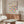 May include: Colorful geometric Bauhaus poster with split circles in vibrant blues, oranges, purples, yellows and pinks, displayed in thin wooden frame above walnut credenza. Modern living room setting with white curved chair, glass oval coffee table, and natural lighting creating soft shadows on neutral walls.