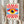 May include: Person holding a framed Bauhaus-style poster featuring a stylized eye with blue iris, yellow surrounding area, and red radiating sunburst pattern against cream background. Light wood frame, neutral room setting with dried pampas grass visible to the left.