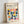 Framed poster with cream background featuring colorful geometric half-circle and oval shapes in yellow, pink, coral, navy, teal, orange, and lavender. Black text at top reads "BAUHAUS Modernism, minimalism & abstract arts 1919-1933" and "SCHOOL OF ARCHITECTURE WEIMAR, DESSAU, BERLIN." Light wood frame sits against white wall casting soft shadows.