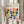 May include: Person holding framed Bauhaus poster featuring colorful geometric semicircle pattern in navy, yellow, pink, orange, teal and mint green. Light wood frame against cream background with dried pampas grass stems visible. Minimalist modernist design with clean typography referencing the architecture school's 1919-1933 period.
