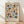 May include: Framed geometric art print featuring colorful circles and semicircles in muted blue, coral pink, olive green, mustard yellow, and navy arranged in a grid pattern on cream background. Text reads "BAUHAUS 1919-1933 SCHOOL OF ARTS & CRAFTS" below the design. Natural wood frame sits on light wooden floor against white wall with soft sunlight shadows.