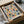 May include: Framed Bauhaus poster with geometric pattern of overlapping circles in muted colors including sage green, dusty pink, navy blue, mustard yellow, and light blue on cream background. Text reads "BAUHAUS 1919-1933" at bottom. Print shown in black frame, partially unwrapped from cardboard packaging with tissue paper on white surface.