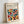 May include: Framed geometric art print in light wood frame leaning against white wall. Design features colorful overlapping semicircles and quarter-circles in earth tones including orange, teal, sage green, burgundy, and mustard yellow on cream background. Text reads "BAUHAUS Modernism, minimalism & abstract arts 1919-1933" and "SCHOOL OF ARCHITECTURE WEIMAR, DESSAU, BERLIN" at top. Modern minimalist home decor styling.