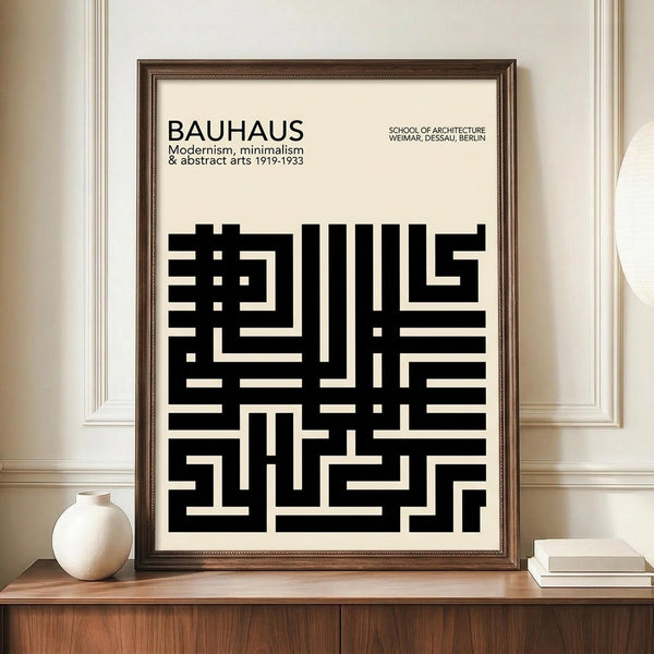 May include: Framed Bauhaus-inspired poster with black geometric maze-like pattern on cream background, displayed on wooden sideboard next to white ceramic vase and stacked books in elegant room with white paneled walls and crown molding.