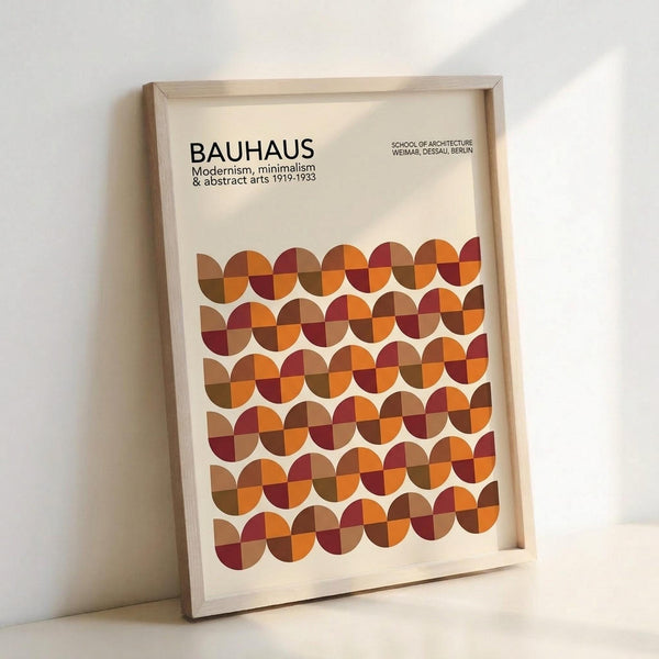 May include: Framed Bauhaus-inspired poster with geometric pattern of overlapping circles in warm autumn colors including orange, burgundy, brown, and rust tones arranged in rows. Text reads "BAUHAUS Modernism, minimalism & abstract arts 1919-1933" and "School of Architecture Weimar, Dessau, Berlin." Light wood frame against white wall with soft shadow cast to the right.