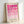 May include: Framed geometric art print leaning against white wall, featuring pink circles and semicircles in gradient shades from bright magenta to pale pink arranged in a grid pattern, with "BAUHAUS 1919-1933 SCHOOL OF ARTS & CRAFTS" text at bottom, displayed in light wooden frame on cream background