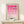 May include: Framed geometric art print with pink circular and semi-circular shapes arranged in a grid pattern, displayed on a light wood console table. The poster features a gradient from bright fuchsia at top to pale pink at bottom with "BAUHAUS 1919-1933 SCHOOL ARTS CRAFTS" text. A small white wrapped gift sits beside the natural wood frame against a cream wall.