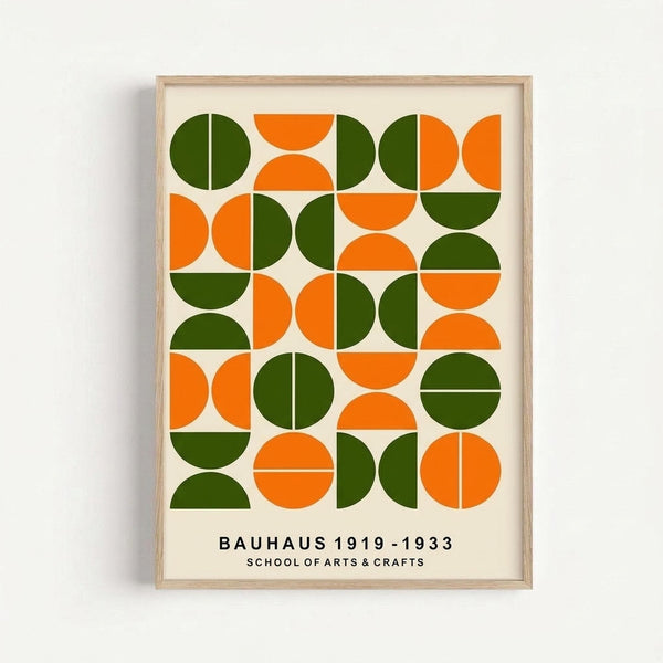 Framed geometric art print featuring a grid pattern of circles and semicircles in bright orange and forest green on cream background. The minimalist design shows various arrangements of full circles, half circles, and quarter circles creating a rhythmic pattern. Text at bottom reads "BAUHAUS 1919-1933 SCHOOL OF ARTS & CRAFTS" in black letters. Natural wood frame against white wall background.