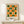 May include: Framed geometric poster with green and orange circles and semicircles arranged in a grid pattern on cream background, displayed on light wood console table next to small white gift box, against neutral wall with natural lighting