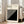 May include: Large framed poster with cream background leaning against white wall next to beige sofa. Black text reads "BAUHAUS Modernism, minimalism & abstract arts 1919-1933" and "SCHOOL OF ARCHITECTURE WEIMAR, DESSAU, BERLIN". Features bold black diagonal striped geometric design in lower portion. Natural wood frame, bright room with windows, hardwood floors.