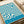 May include: Blue and cream wavy striped abstract poster with flowing, psychedelic-style lines and "BAUHAUS AUSSTELLUNG Juli-Sept 1923" text, displayed in an open book or portfolio on a beige surface next to white paper rolls, showing the vintage exhibition design in warm natural lighting.