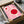 May include: Pink and red Bauhaus-style poster with geometric circular shapes in black frame, partially unwrapped from cardboard packaging with tissue paper, surrounded by craft supplies and wooden handles on neutral surface