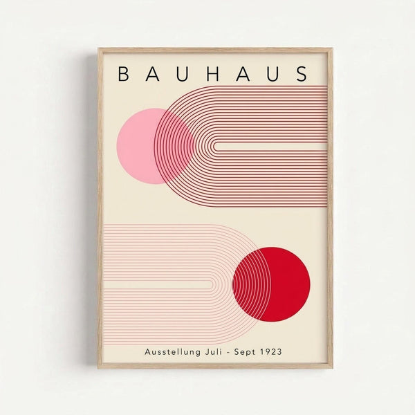 May include: Framed Bauhaus-style poster with geometric design featuring pink and red circles intersected by curved linear patterns on cream background, displayed on white wall in light wood frame