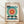 May include: Framed Bauhaus-style poster with geometric design featuring a large teal circle with radiating red and white rays around yellow center, black horizontal lines and angular shapes, displayed against white wall on light wooden floor with soft shadows