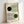 May include: Framed Bauhaus poster with geometric design featuring two curved line patterns - one in green lines with black circle, one in black lines with green circle. Clean minimalist artwork in light wood frame leaning against white wall on light surface.