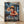 May include: Framed One Piece anime poster showing Luffy in his signature straw hat and red vest, throwing a flaming punch on a stormy ship deck with lightning and turbulent seas. The poster features Japanese text and English subtitle "The Gum-Gum Wrath" in a light wood frame, leaning against a white wall on wooden flooring with natural lighting casting shadows.