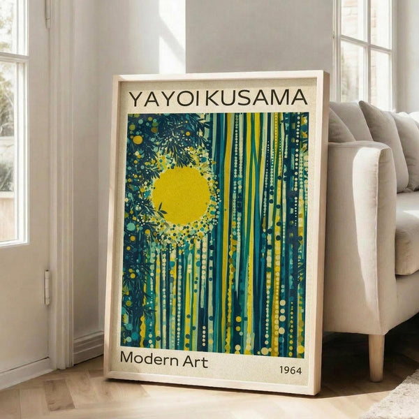 May include: Framed art print leaning against white wall next to beige sofa in bright room with large windows. Print features abstract design with bright yellow sun, teal and green vertical stripes, scattered dots, and dark foliage silhouettes. Text reads "YAYOI KUSAMA" at top, "Modern Art" and "1964" at bottom. Light wood frame, cream matting.