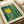 A vintage-style art poster featuring a vibrant abstract composition with a bright yellow sun or moon surrounded by teal and green vertical streaks resembling bamboo or forest elements, decorated with scattered dots and organic shapes. The print has cream borders with "YAYOI KUSAMA" at top, "Modern Art" at bottom, and "1964" in the corner, displayed on white paper with neutral packaging materials visible in the background.