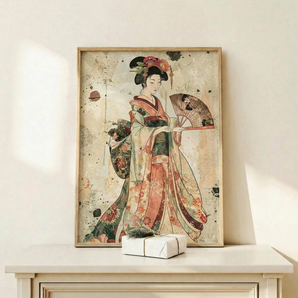 May include: Framed vintage-style Japanese geisha artwork displayed on light wood shelf against white wall. Print shows woman in elaborate floral kimono holding decorative fan, with weathered beige background and scattered dark spots. Simple wooden frame matches shelf. Small white geometric object sits nearby for scale.