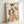 May include: Framed vintage-style Japanese artwork showing a geisha in colorful floral kimono holding a decorative fan, displayed in light wood frame against white wall. The print features weathered, distressed background with paint splatters and aging effects in muted earth tones.