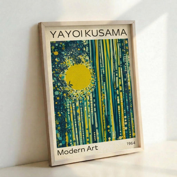 A framed poster featuring abstract art with a bright yellow sun surrounded by radiating vertical streaks in teal, green, and yellow tones, dotted with circular polka dot patterns. The artwork has "YAYOI KUSAMA" at the top, "Modern Art" at the bottom left, and "1964" at the bottom right on a cream background. The natural wood frame leans against a white wall, casting a soft shadow.