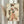 May include: Framed vintage-style Japanese geisha artwork displayed on easel beside dried pampas grass stems. The print features a woman in elaborate floral kimono holding decorative fan, rendered in soft coral, green and cream tones with distressed aging effects. Light wooden frame against neutral curtained background creates elegant home decor styling.
