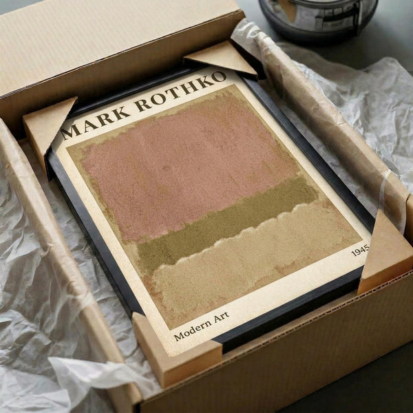 May include: Abstract art print with horizontal bands of muted pink, olive green, and beige tones in earthy color palette, displayed in black frame within brown cardboard packaging box surrounded by white tissue paper on neutral surface