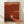 May include: Framed poster with rust-red background featuring silhouette of person walking through white doorway opening. Text reads "The Threshold Project Walking Into The Unknown" at top and "Tate Modern, London 10 February 2001 - 2 June" with additional exhibition details. Natural wood frame displayed against white wall on light wooden floor with soft shadows.