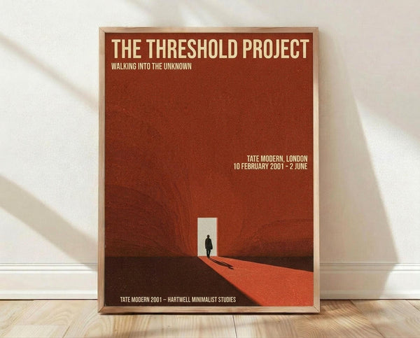 May include: Framed poster with rust-red background featuring silhouette of person walking through white doorway opening. Text reads "The Threshold Project Walking Into The Unknown" at top and "Tate Modern, London 10 February 2001 - 2 June" with additional exhibition details. Natural wood frame displayed against white wall on light wooden floor with soft shadows.