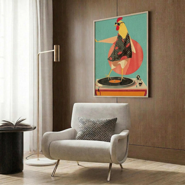 May include: Colorful retro poster featuring a anthropomorphic chicken character with yellow head and red comb, wearing polka dot outfit, positioned above orange turntable on teal background. Framed artwork hangs on wood-paneled wall above cream upholstered chair with geometric throw pillow. Modern brass floor lamp and dark side table with open book complete the contemporary living room setting.