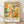 May include: Framed poster with abstract modernist artwork featuring hundreds of small colorful human figures in geometric shapes scattered across a warm golden, orange, and teal background. The print displays "PAUL KLEE" in large black text below the artwork, with "PLAYFUL ABSTRACTION MODERNISM 1879-1940" in smaller text. Light wood frame leans against white wall on natural wood flooring with soft shadows.