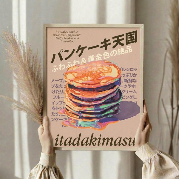 May include: Person holding framed poster print featuring colorful stack of pancakes with Japanese text on pink background. Frame appears light wood, person wears cream colored clothing with ruffled sleeves, holds dried wheat stems. Soft natural lighting against neutral curtained background. Poster shows vibrant pancakes in rainbow colors with syrup dripping, Japanese characters, and "itadakimasu" text at bottom.