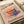 May include: Colorful poster print featuring a stack of fluffy pancakes with vibrant purple, orange, pink and teal syrup dripping down. Japanese text surrounds the artwork on cream-colored paper. The print sits on a white surface next to rolled white paper, showing the poster's size and matte finish texture.