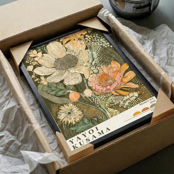 May include: Vintage botanical art print in black frame inside cardboard shipping box with protective tissue paper. Artwork features large detailed flowers in cream, pink and orange tones with green leaves on olive background with dotted patterns. Print shows artist signature and appears to be museum-quality reproduction with warm, earthy color palette.