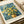 May include: Van Gogh museum poster print showing yellow chrysanthemum flowers in a brown vase against swirling blue brushstroke background, displayed on white bedding next to cream ribbon, featuring museum text at bottom