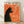 May include: Framed vintage-style poster with orange background featuring black cat silhouette smoking a cigarette with green smoke curls. French text reads "Le Chat Nocturne" at top. Poster displays exhibition details for Paris museum show from 2008. Light wood frame rests against white wall on wooden floor with natural shadows.