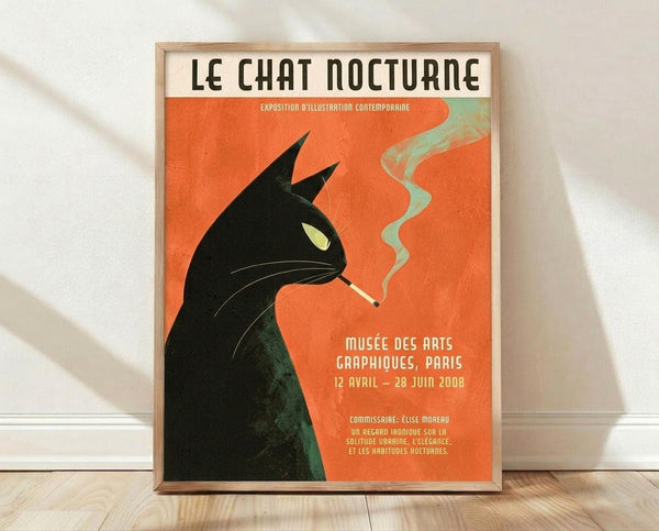 May include: Framed vintage-style poster with orange background featuring black cat silhouette smoking a cigarette with green smoke curls. French text reads "Le Chat Nocturne" at top. Poster displays exhibition details for Paris museum show from 2008. Light wood frame rests against white wall on wooden floor with natural shadows.