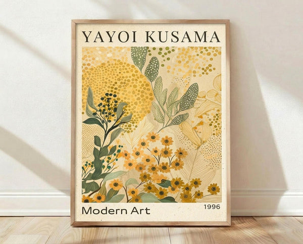 May include: Framed botanical art print leaning against white wall on light wood floor. The poster features abstract yellow and green foliage with dotted patterns and small flowers in warm earth tones. Text reads "YAYOI KUSAMA" at top and "Modern Art 1996" at bottom. Natural wood frame surrounds cream-colored background with organic plant motifs in contemporary artistic style.