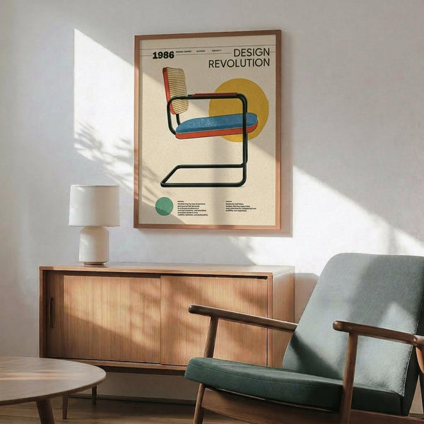 May include: Framed vintage-style poster featuring a modernist cantilever chair with cane backrest, blue seat cushion, and yellow geometric circle accent against cream background. Displayed above wooden credenza with white ceramic lamp in mid-century modern living room setting with gray upholstered armchair and natural lighting casting geometric shadows on white wall.