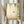 May include: Person in cream ruffled sleeves holding framed botanical wall art featuring green hummingbird flying among hanging ferns and trailing vines on textured beige background, displayed in light wood frame near dried pampas grass against white curtained window