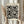 May include: Person in beige ruffle-sleeve top holding framed black and white polka dot art print while standing near dried pampas grass against soft white curtained background. The artwork features various sized black circles and dots in Kusama's signature infinity net style, displayed in light wood frame.