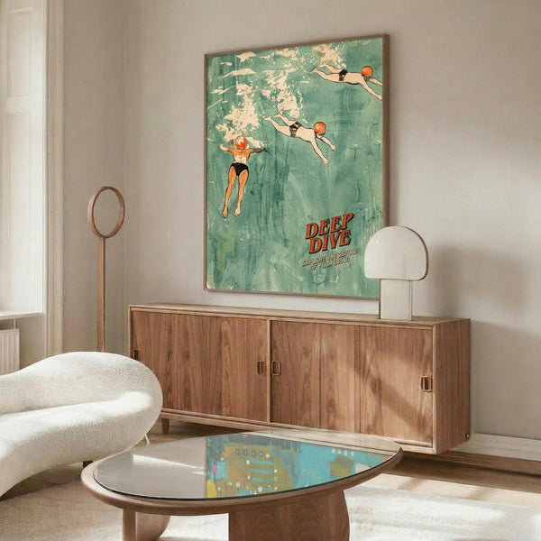 May include: Vintage-style poster with turquoise water showing three swimmers diving and floating, red "DEEP DIVE" text at bottom, displayed above walnut wood credenza in modern living room with white curved chair, glass coffee table, and minimalist white table lamp
