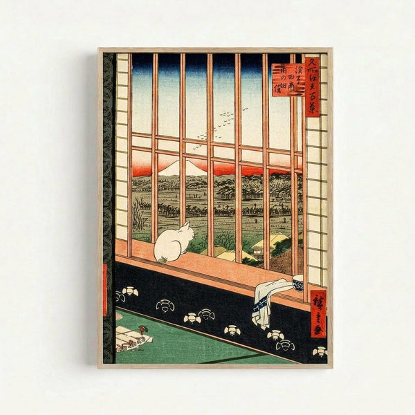 Japanese woodblock print showing interior view through wooden latticed window frame. White cat sits on windowsill overlooking rural landscape with Mount Fuji in distance under orange sunset sky. Dark wooden floor with green tatami mat below. Traditional ukiyo-e art style with blue gradient sky, red cartouche with Japanese text in upper right corner. Framed print mounted on white wall.