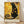 May include: Framed poster print featuring a black cat in Gustav Klimt's golden art style with ornate circles, geometric patterns, and decorative swirls on a golden yellow background. Text reads "Nine Lives of Luxury" and "No Paws in My Plans, Only Purrfection." Light wood frame displayed on wooden floor against white wall with natural lighting.