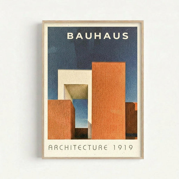 Framed poster with geometric abstract buildings in orange, cream, and brown tones against a dark blue background. The word "BAUHAUS" appears in white letters at the top, with "ARCHITECTURE 1919" at the bottom. The artwork features angular, overlapping architectural forms creating depth and shadow. Displayed in a natural wood frame with white matting against a light gray wall.