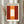 May include: Framed art print in light wood frame hanging on white wall next to dried pampas grass. Abstract painting features warm orange and red color blocks with glowing white rectangular center. Modern minimalist interior setting with natural lighting and neutral tones.