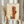 May include: Person in beige clothing holding framed Paul Klee abstract art print featuring geometric shapes in warm orange, rust, and blue tones with delicate line drawings on cream background. Light wooden frame, pampas grass decoration, soft natural lighting against neutral curtained backdrop.
