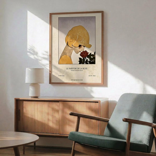 May include: Art Deco style poster showing woman in golden cloche hat smelling dark red rose, displayed in thin wooden frame above mid-century modern wooden credenza with white ceramic lamp, beside sage green upholstered armchair with wooden arms in sunlit room with white walls