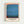 Framed abstract color field print featuring horizontal bands of blue and teal with orange and red accents along the edges. The artwork has a soft, watercolor-like texture with blended transitions between colors. Below the image is text reading "THE MODERNIST ARCHIVE MARK ROTHKO HISTORY OF PAINTING" with additional smaller text including "MODERN ART," "CHROMA STUDIES," and "1950s." The print is displayed in a light wood frame against a white wall.